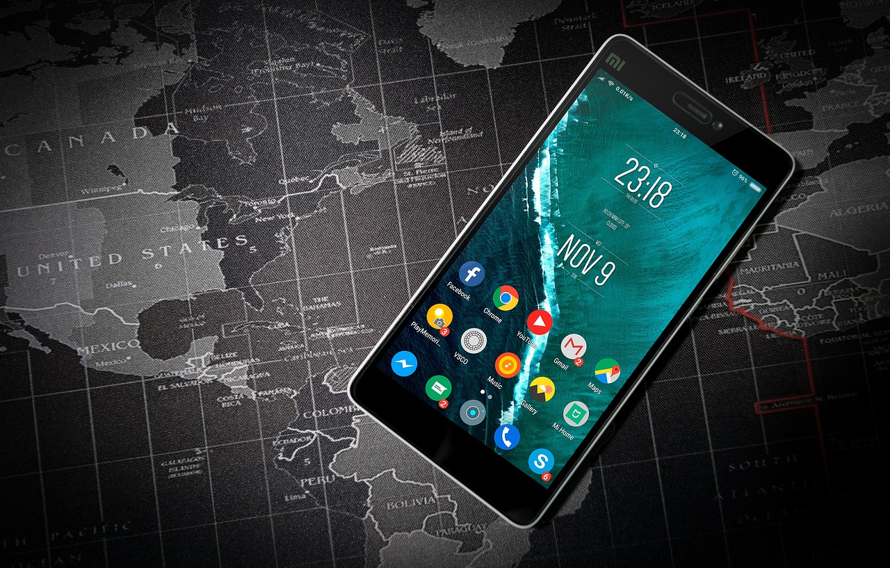Smartphone displaying various app icons over a world map background, symbolizing the global impact of online reviews on local SEO strategies.
