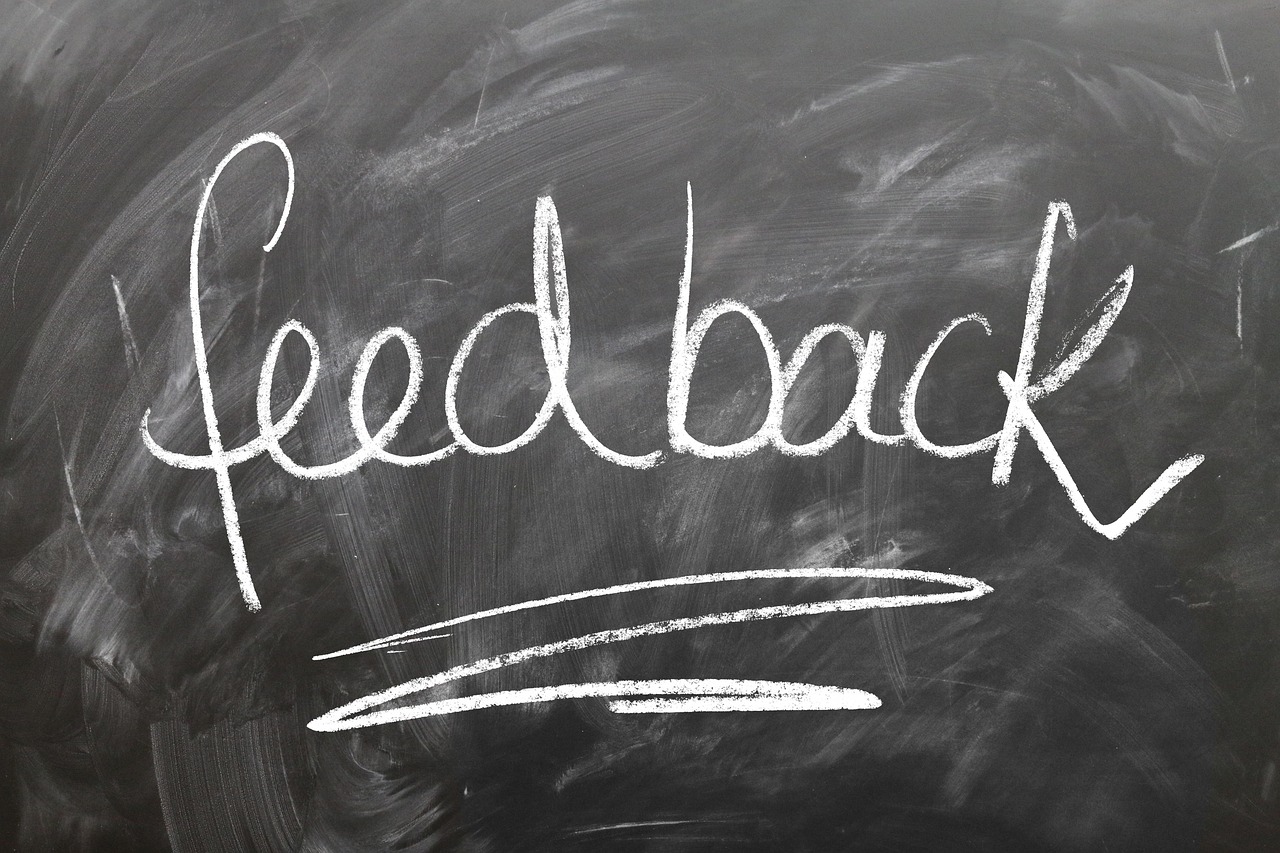 The word "Feedback" written in white chalk on a blackboard, emphasizing the importance of customer feedback in optimizing local business listings.